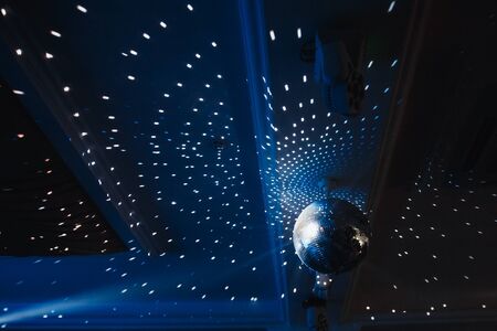 Disco ball with searchlight bright rays. Background night partyの写真素材
