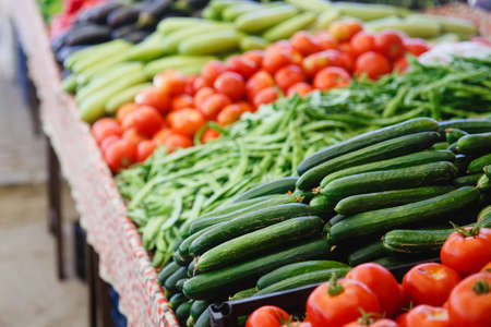 cucumbers on the store counter. Tomatoes are in the background.の写真素材
