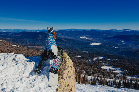 Sheregesh, Kemerovo region, Russia - April 16, 2016: Snowboarder in the background of mountains and blue skyのeditorial素材