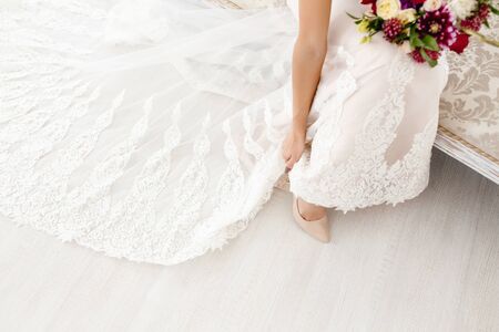 The bride is wearing wedding shoes, in a wedding dress.の写真素材