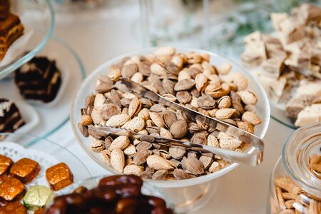 cater table with a mixture of nuts almonds and apricot stoneの写真素材
