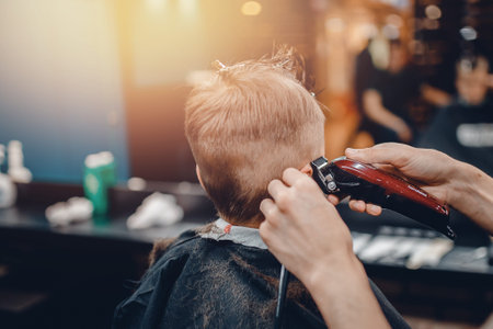Barber shop. Barbershop little boy getting his head shaved by barberの写真素材