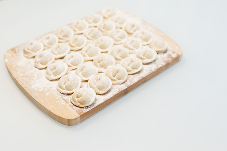 pelmeni. close-up on a wooden board with flourの写真素材