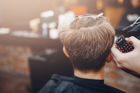 Barbershop. Close-up of man haircut, master does the hair styling in barber shopの写真素材