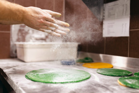 Master prepares a color dough for acrobatics of a pizza, bezdrozhzhevoj, sports competition. Flour, dusの写真素材