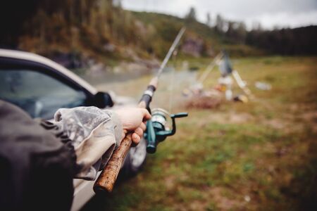 Fishing, a first-person view, a fisherman holding a fishing rod for catching fish in his handの写真素材