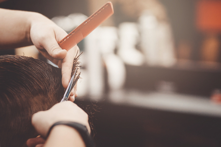 Barbershop. Close-up of man haircut, master does the hair styling in barber shopの写真素材