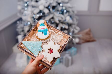 Gingerbread deer new year. Gingerbread on glowing lights of a Christmas tree. Concept of sweets and giftsの写真素材