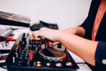 Remote DJ. Close-up of musician's hand on remote in nightclubの写真素材
