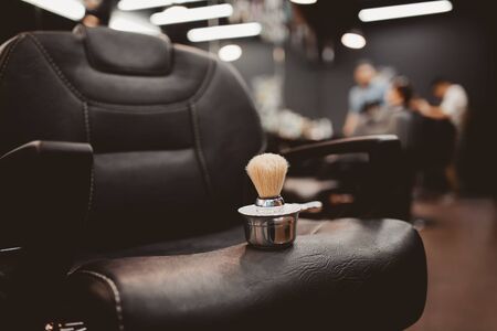 brush for shaving beard along with bowl, blurred background of hair salon for men, barber shopの写真素材