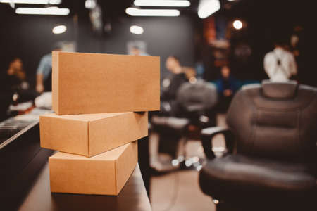 Barbershop. Pile of boxes with gifts, in the background a barber chair. Place for your text. copyspaceの写真素材