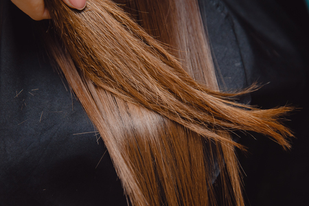 Comparison of healthy and broken, sick hair in a girl.の写真素材