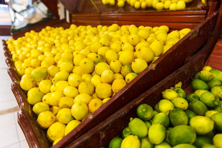 Store bazaar of fresh fruit. Yellow lemons and limes in boxesの写真素材