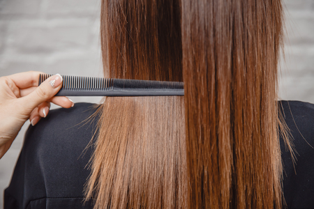 Master combs hair with his teeth in salon. Beautiful and healthy.の写真素材
