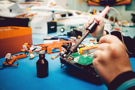 Man holds soldering iron, constructs automodels, solder schemes, assemble model on radio controlの写真素材