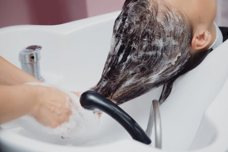 Salon hair salon, master washes hair and massages girl's headの写真素材