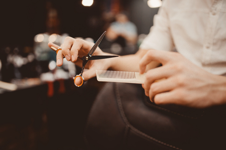 Barber shop. Close-up of barber holds clip-on hair clipper barbershopの写真素材