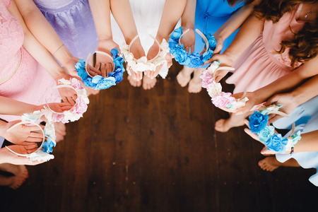 Friends of the bride podgotavlivayutsya to the hen party and holding wreaths for the hair, the girls in blue, pink dresses. Concept wedding, weddingの写真素材