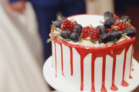 Bride and groom cut wedding cake with fresh flowers rose with knife. Coupの写真素材