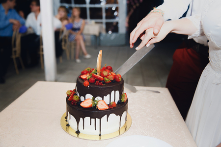 Bride and groom cut wedding cake with fresh flowers rose with knife. Coupの写真素材