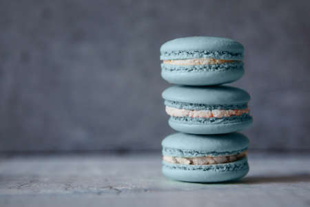 Macaroon. Macaron on gray neutral loft background, stand on plate of different colors. Wooden background.の写真素材