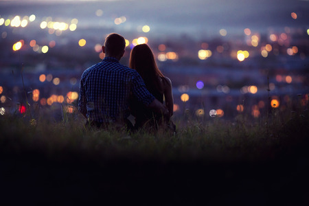 Lovers man and girl against background night city, night starry sky and horizon. Concept date Valentine's Day, first kiss love, forever together.の写真素材