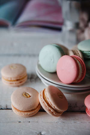 Macaroon. Macaron on gray neutral loft background, stand on plate of different colors. Wooden background.の写真素材