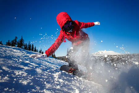 Snowboarder on snowboard rides through snow, explosion. Freeride snowboarding in Sheregesh Ski Resortの写真素材