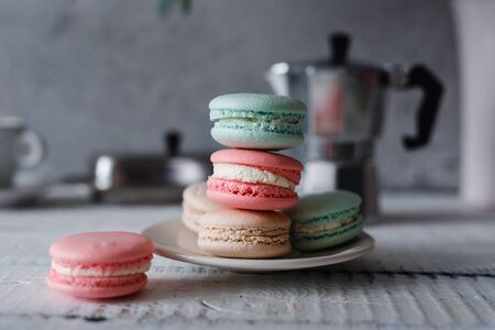 Macaroon. Macaron on gray neutral loft background, stand on plate of different colors. Wooden background.の写真素材