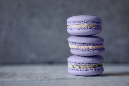 Macaroon. Macaron on gray neutral loft background, stand on plate of different colors. Wooden background.の写真素材