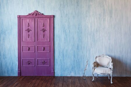 Blue wall cement, pink purple double-leaf door, loft furniture armchair. Copyspaceの写真素材