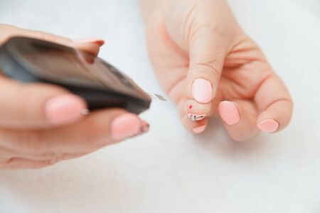 Glucometer. Woman checks blood sugar level for diabetes, insulin levelsの写真素材