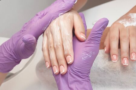 Cream. Master applies cream to moisturize skin of hands. Concept spa salon manicure.の写真素材