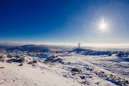 Snowboard. Snowboarder stands with his back on top of mountain and looks into distance clear sky. Concept loneliness with yourself, reach goal, first placeの写真素材