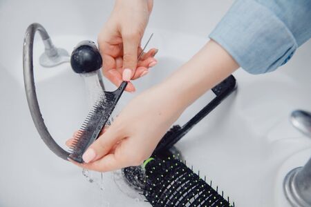Hairdresser cleans tools with comb and clamps.の写真素材