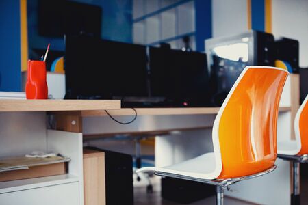 Workplace. Modern Chair in orange stands computer tableの写真素材