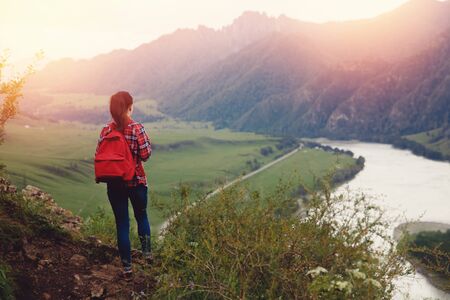 Girl traveler with backpack hiking. Concept travel, lifestyle adventure active summer vacations outdoor rocky background mountainsの写真素材