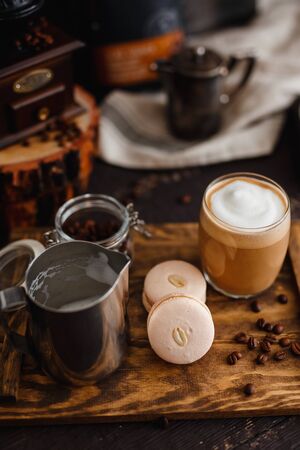 Large grain of coffee, a glass of coffee, and milk latte latte, two macaroons. Stand on a wooden tray, breakfastの写真素材