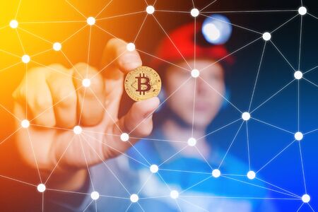 Bitcoin ico. Golden bitcoin on hand miner background. Concept Blockchain, hardfork.の写真素材