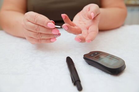 Glucometer. Woman checks blood sugar level for diabetes, insulin levelsの写真素材