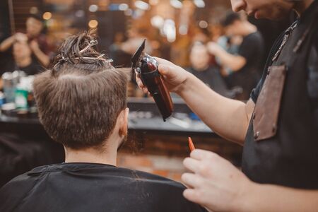 Barber shop. Barber shears client with hair machine. Barbershopの写真素材