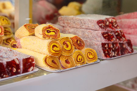 Turkish sweet delight with almond, cashew and pistachio nuts on plates. Eastern sweets in a wide baklava range,の写真素材