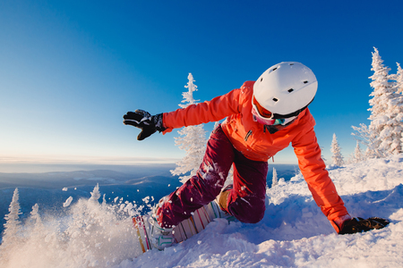 Snowboarder on snowboard rides through snow, explosion. Freeride snowboarding in Ski Resortの写真素材