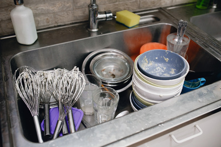 Dirty dishes. Remains of food on dishes in sink in kitchen.の写真素材