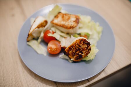 Preparation of fresh salad from cherry tomatoes, fried cheese, Peking cabbage, chilli and mango sauceの写真素材