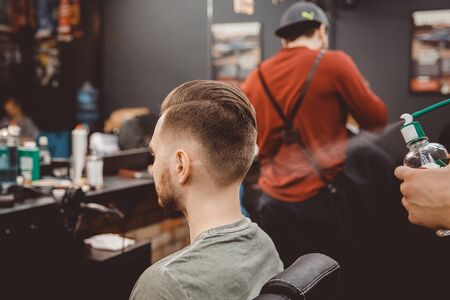 Barber shop. Man with wife in barber's chair, hairdresser Barbershop styling his hairの写真素材