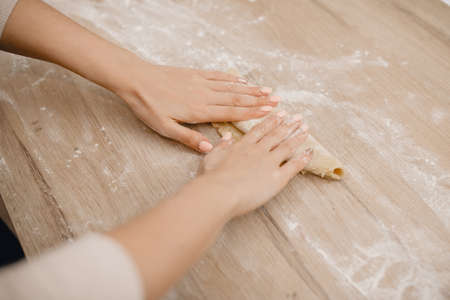 Girl rolls out dough for making Italian pastaの写真素材
