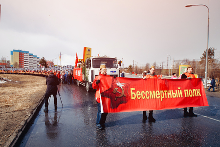 Murmansk, RUSSIA - MAY 9, 2017: Immortal regiment procession in Victory Day. Thousands of people marching to Square with flags and portraits in commemoration of soldiers of World War IIのeditorial素材