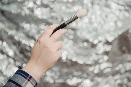 Makeup brush. A woman make-up artist holds make-up brush.の写真素材