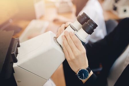 Microscope. Close-up of male student holding his hands microscope. Concept science, school laboratory.の写真素材